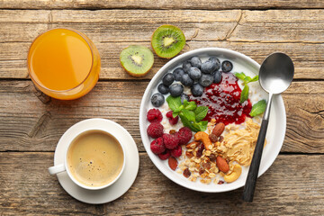 Healthy breakfast. Oatmeal with nuts, berries, yoghurt, coffee and orange juice on wooden table, flat lay
