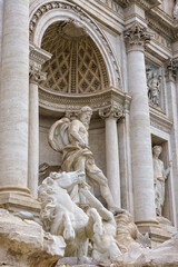 Fototapeta premium Rome, Italy. Detail of the Trevi Fountain featuring marble statues, sculpted rocks, and dynamic Baroque figures carved in white stone.