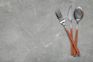 Silver cutlery on grey background