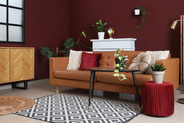 Fototapeta premium Interior of modern living room with cozy brown sofa, coffee table, ottoman and fireplace