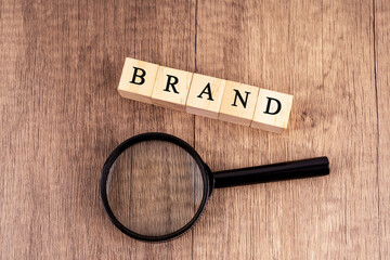 Magnifying glass and wood block with text Brand