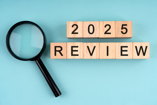 Magnifying glass and wood block with text 2025 review