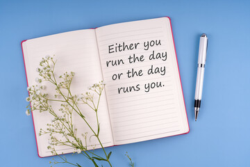 Notepad with inspirational quote -Either you run the day or the day runs you