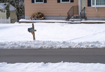 front view of residential house and street after snow