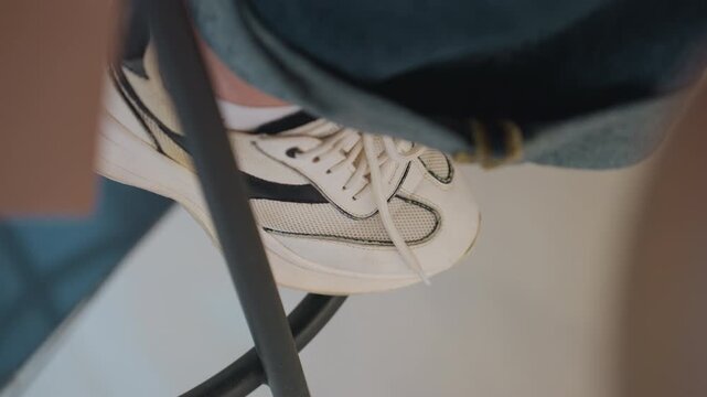 closeup of sport shoe in city environment, urban styled sneaker placed on stool among city surroundings, detailed view of casual athletic footwear resting on stool within urban background