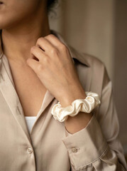 A person with a beige ruffled scrunchie