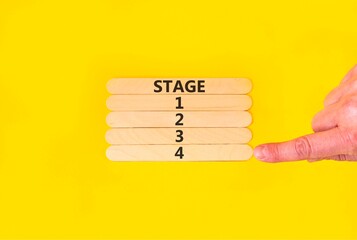 Time to stage 4 symbol. Concept word Stage 1 2 3 4 on beautiful wooden sticks. Businessman's hand. Beautiful yellow background. Business planning and time to stage 4 concept. Copy space.