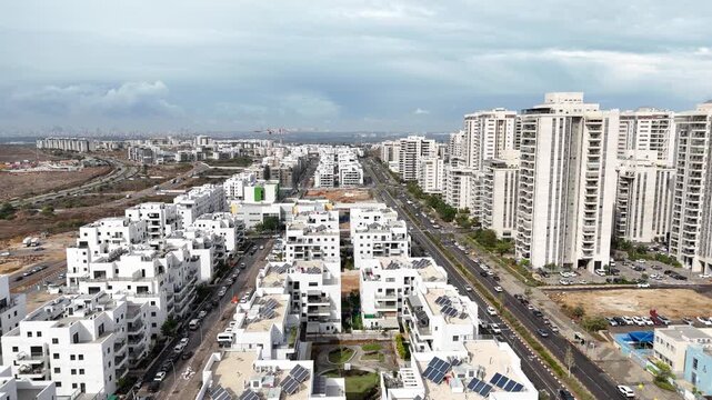 Aerial drone view of Afula, a city in northern Israel, showing urban neighborhoods, residential buildings, roads, and surrounding landscape. Modern Israeli cityscape captured from above, highlighting 