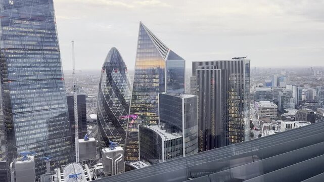 Aerial drone view of London skyline with the famous River Thames flowing through the city and the iconic Tower Bridge connecting both sides. Stunning panoramic view of modern skyscrapers and historic 