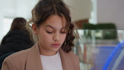 female individual compares different manicure polish tones and samples attentively, young woman carefully evaluates multiple nail polish color samples and swatch options before choosing