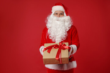 Santa Claus with Christmas gift on red background