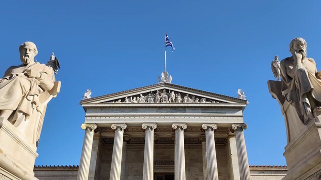 Exterior view of the Academy of Athens, the centerpiece of Theophil Hansen&rsquo;s Neoclassical Trilogy, standing in downtown Athens, Greece, adorned with the statues of Plato and Aristotle.