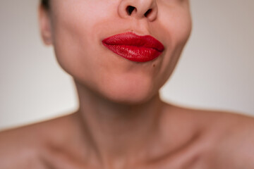 Close-up of young woman's lips with red lipstick and smooth skin. Natural beauty, sensual makeup...