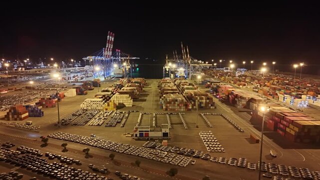 Night view of Ashdod Port in Israel illuminated with industrial lights. Cargo cranes, shipping containers and maritime infrastructure operating after dark along the Mediterranean coast. Concept of glo