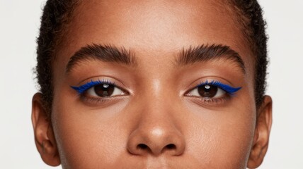Woman with blue eyeliner and natural makeup, close-up of face and eyes with defined eyebrows