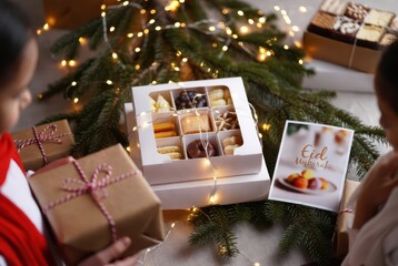 Assorted holiday sweets in gift box with Christmas lights