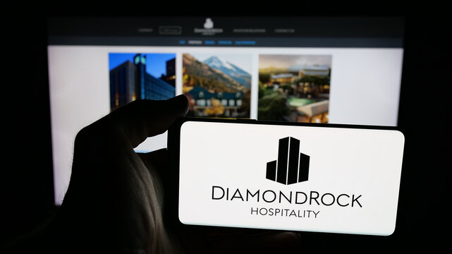 Stuttgart, Germany - 12-08-2025: Person holding mobile phone with logo of REIT business DiamondRock Hospitality Company on screen in front of web page. Focus on phone display.
