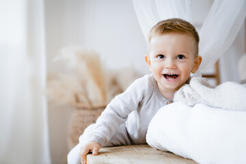 Small little caucasian toddler child kid son daughter smiling with first teeth, playing at home. Child care concept. Parenthood. Advertisement for children's products, clothing