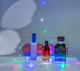 View of perfume bottles with a background of red Christmas tree baubles and lights