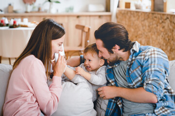 Young loving family playing with little small child kid son daughter toddler, hugging and embracing at home. Child care and parenthood concept. Insurance mortgage for people