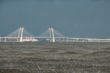 Obraz premium cable-stayed bridge and hydrofoil boat in the background, water surface of the Gulf of Finland in heavily rain, raindrops, storm, Russia, Saint-Petersburg