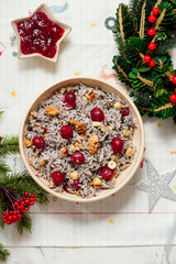 Traditional Christmas Ukrainian rice kutia with cherry, honey and poppy seeds on a Christmas rustic background