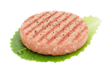 Raw burger patty with grill marks isolated on lettuce leaf PNG, uncooked ground meat for grilling and barbecue