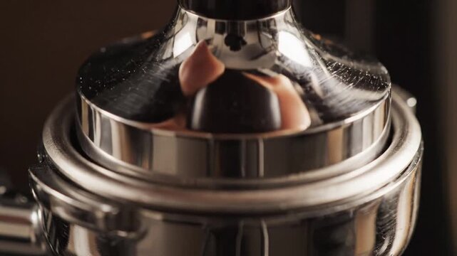 Close up of espresso machine with shine on metal surface and coffee grounds