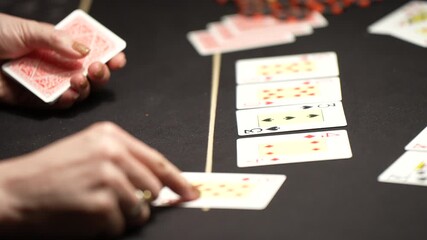 Detailed casino poker video showing dealer hands revealing and positioning playing cards on professional felt table during decisive betting stage