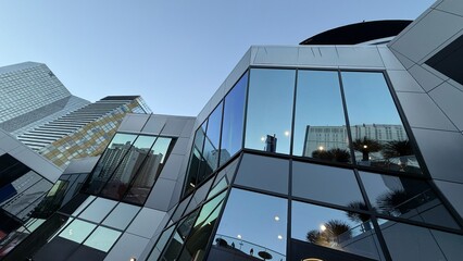 Modern Las Vegas Architecture with Glass Skyscrapers and Reflections of City Life. Glittering glass skyscrapers in Las Vegas reflect the blue sky, palm trees, and city streets.
