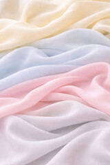Obraz premium Soft pastel fabric texture background with flowing folds of pink white and beige textile creating elegant abstract fashion and interior design backdrop