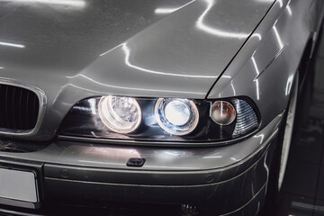 Detailed view of angel eyes and projector lenses in a clean headlight after deep polishing and cleaning. High-quality automotive optics restoration in a specialized detailing center. © 072Y