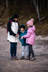 Obraz premium Mother guiding children on a winter nature walk