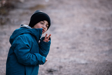 Boy making peace sign with playful expression