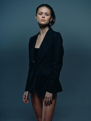 confident woman wearing black blazer with serious expression in dark studio lighting