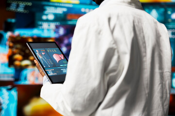 Close up of researcher looking at xray scans data on digital device display. Scientist analyzing neurology research on tablet screen, looking at pictures of human organs, comparing metrics