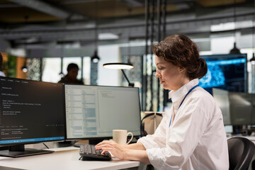 System administrator in Silicon Valley company office developing software apps. IT professional using computer at work to do coding, debugging applications to resolve issues