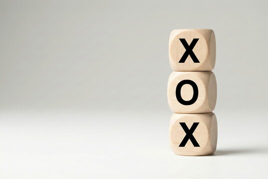 Stacked XOX wooden blocks symbolizing strategy, competition, and decision-making on a clean, minimalist background with copy space.