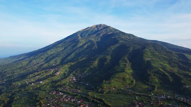 Aerial drone footage of Merbabu volcano, and the surrounding national park, Selo area, villages and gardens, in Indonesia, at sunrise