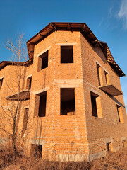 The exterior of an unfinished cottage with brick walls and windows
