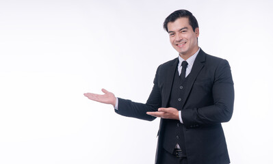Professional handsome businessman in black suit presenting empty copy space with open palms on white background. Happy male entrepreneur welcoming client or showing product concept.