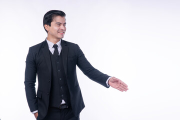 Professional handsome businessman in black suit offering handshake on white background. Happy male entrepreneur welcoming client for partnership deal concept with smile.