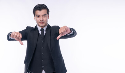 Serious handsome businessman in black suit showing thumbs down gesture with both hands on white background. Unhappy male entrepreneur disapproving bad product or rejecting concept.