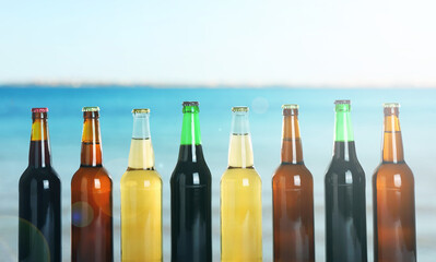 Bottles of beer near sea. Refreshing summer drink