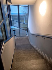 A modern staircase in an office building with panoramic windows and lighting fixtures