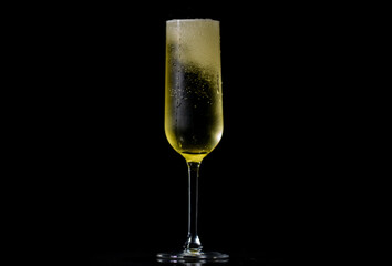Champagne sparkling in a wine glass. Champagne with festive bubbles. Sparkling wine splash in wineglass. Champagne drink with golden fizz on black background. Pour of champagne with bubbles.