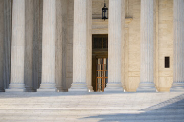 White stone columns express civic architecture. Supreme Court columns suggest justice and...