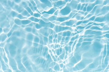 Blue water with ripples on the surface. Defocus blurred transparent blue colored clear calm water surface texture with splashes and bubbles. Water waves with shining pattern texture background.