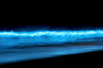 Bioluminescent waves glowing at night on a tranquil beach coastline