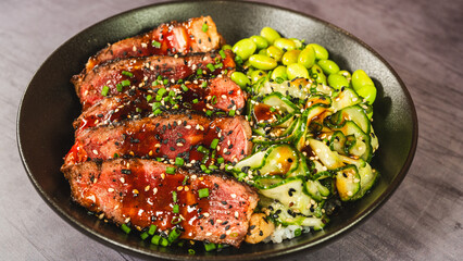 Beautiful oriental bowl with thin slices of rare sirloin, edamame, sunomono salad, and teriyaki sauce. Vibrant colors, fresh ingredients, perfect for a healthy and gourmet meal.